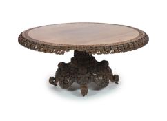 A 19th-century Ceylonese rosewood centre table,The circular tilt top with carved and pierced folate
