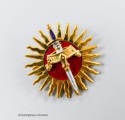 A modern 9ct gold and red enamel brooch, modelled as a sword and crown, with sun background,