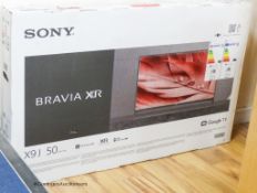 An unopened Sony Bravia X9J 50 television with sound bar