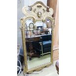 A George I style gilt composition wall mirror, having arched rectangular plate and shaped frame,