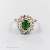 A modern 18ct white gold, green garnet and diamond set oval cluster ring, size N, gross weight 5.3