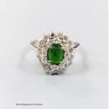 A modern 18ct white gold, green garnet and diamond set oval cluster ring, size N, gross weight 5.3