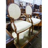 A pair of upholstered elbow chairs, width 57cm, height 100cm