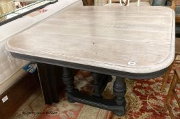 A 19th century French stripped oak and painted extending dining table, 210cm extended, two spare
