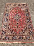 A Kashan red ground rug, with all-over stylised floral motifs