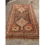 An early 20th century Persian blue ground rug, having three central medallions and floral