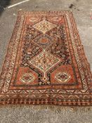 An early 20th century Persian blue ground rug, having three central medallions and floral