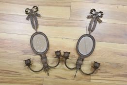 A pair of wrought copper oval two branch girandole mirrors, length 56cm