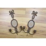 A pair of wrought copper oval two branch girandole mirrors, length 56cm