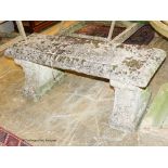 A reconstituted stone bench having moulded rectangular top on acanthus-decorated end supports,