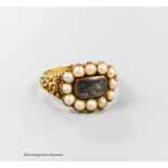 A 19th century yellow metal and split pearl set mourning ring, with plaited hair beneath a glazed