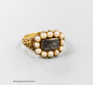 A 19th century yellow metal and split pearl set mourning ring, with plaited hair beneath a glazed
