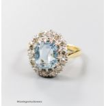 An 18ct, aquamarine and diamond set oval cluster ring, size N, gross 6 grams.