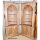 A pair of George III style carved stripped pine niche barrel back open corner cupboards, width