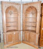 A pair of George III style carved stripped pine niche barrel back open corner cupboards, width