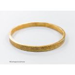 A 1920's engine turned 9ct gold bangle, interior diameter 76mm, 11.9 grams.