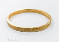 A 1920's engine turned 9ct gold bangle, interior diameter 76mm, 11.9 grams.