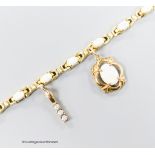 A modern 585 yellow metal and oval white opal set bracelet, hung with two yellow metal charms (