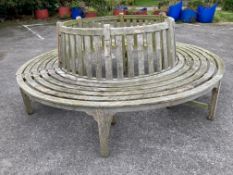 A weathered teak two section garden tree seat, diameter approx. 210cm, height 87cm, aperture