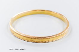 A 1930's engine turned 9ct gold bangle, interior diameter 73mm, 9 grams.