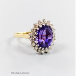 A modern yellow metal, amethyst and diamond set oval cluster ring, size O, gross 5.6 grams.