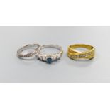 Three modern dress rings including a 750 yellow metal and seven stone channel set diamond crossover