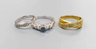 Three modern dress rings including a 750 yellow metal and seven stone channel set diamond crossover