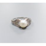 A modern 750 white metal and single stone cultured pearl dress ring, with diamond chip set pierced