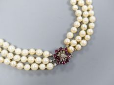 A triple strand cultured pearl necklace, with 585 white metal, ruby and diamond cluster set central