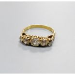 A five-stone diamond ring, yellow metal setting, claw-set with carved shoulders, size N, gross 3