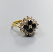 A modern 18ct gold, sapphire and diamond set diamond shaped cluster ring, size M/N, gross 6.1