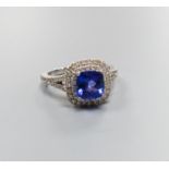 A modern 14k white metal, tanzanite and diamond set square cluster ring, with diamond set split