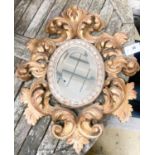 A 1930's Italian carved giltwood oval mirror, width 47cm, height 59cm