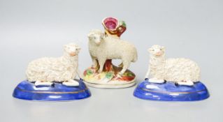 A pair of Staffordshire pottery figures of recumbent sheep, and a similar spell vase, tallest 12.5