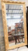 A rectangular carved giltwood framed wall mirror, width 67cm, height 132cm