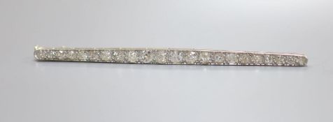 An early 20th century yellow metal and graduated twenty stone diamond set bar brooch, 67mm, 4.9