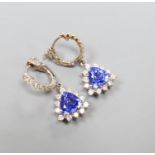 A modern pair of 14k white metal trillion cut tanzanite and diamond chip set cluster drop earrings,