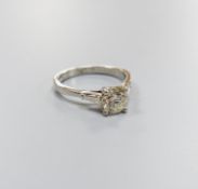 A modern platinum and single stone diamond ring, with trapeze cut diamond set shoulders, size N,