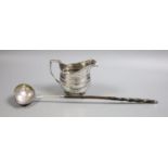 A George III silver cream jug, marks rubbed, height 10.7cm, and a 19th century toddy ladle.