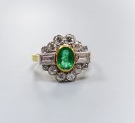 A modern 18ct gold, emerald, baguette and round cut diamond set shaped oval cluster ring, size L/M,