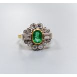 A modern 18ct gold, emerald, baguette and round cut diamond set shaped oval cluster ring, size L/M,