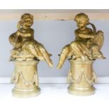 A pair of bronze figures of Cupid on circular pedestals, early 20th century, 42 cm high