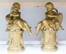 A pair of bronze figures of Cupid on circular pedestals, early 20th century, 42 cm high