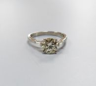 A modern platinum and single stone diamond ring, with trapeze cut diamond set shoulders, size O,