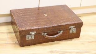 An early 20th century crocodile skin suitcase with blue leather lined interior61cm