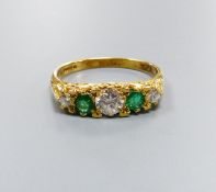 A modern Victorian style 18ct gold, three stone diamond and two stone emerald set half hoop ring,