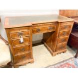 A reproduction yew inverse breakfront kneehole pedestal desk fitted green skiver, width 114cm,