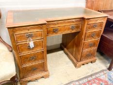A reproduction yew inverse breakfront kneehole pedestal desk fitted green skiver, width 114cm,
