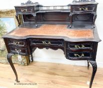 A late Victorian carved mahogany serpentine-shaped writing desk, length 106cm, depth 54cm, height