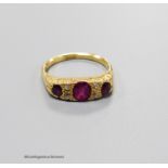 An early 20th century 18ct, three stone ruby and four stone diamond chip set half hoop ring, size